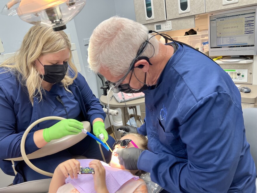 Hal Jeter puts a sealant on a young patient's teeth.