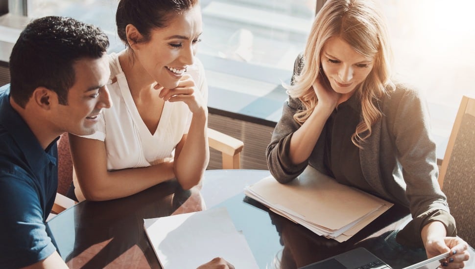 Couple reviewing their financial portfolio and alternative investments with their advisor.